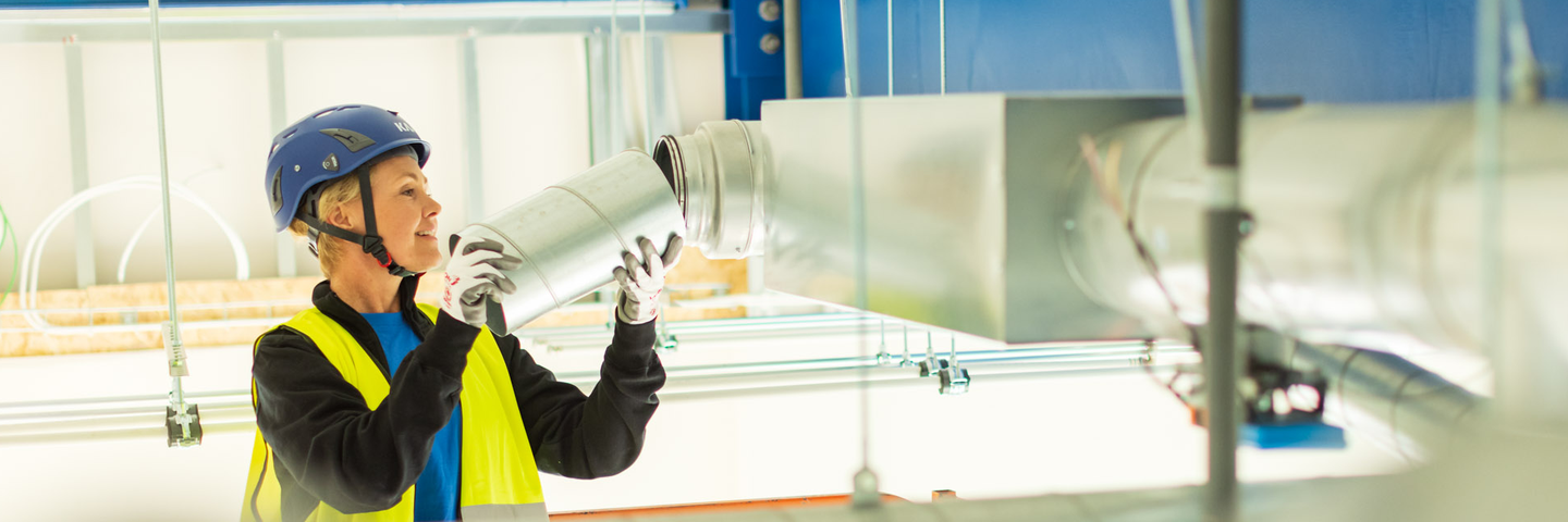 Construction site photo shoot session Experience Center Woman mounting duct Annica Pettersson
