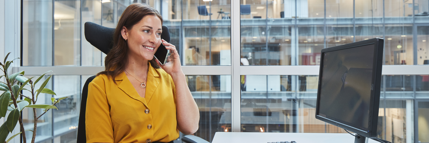 Woman sitting at desk, computer, working, talking on the phone Indoor air environment photo shoot session Aura
